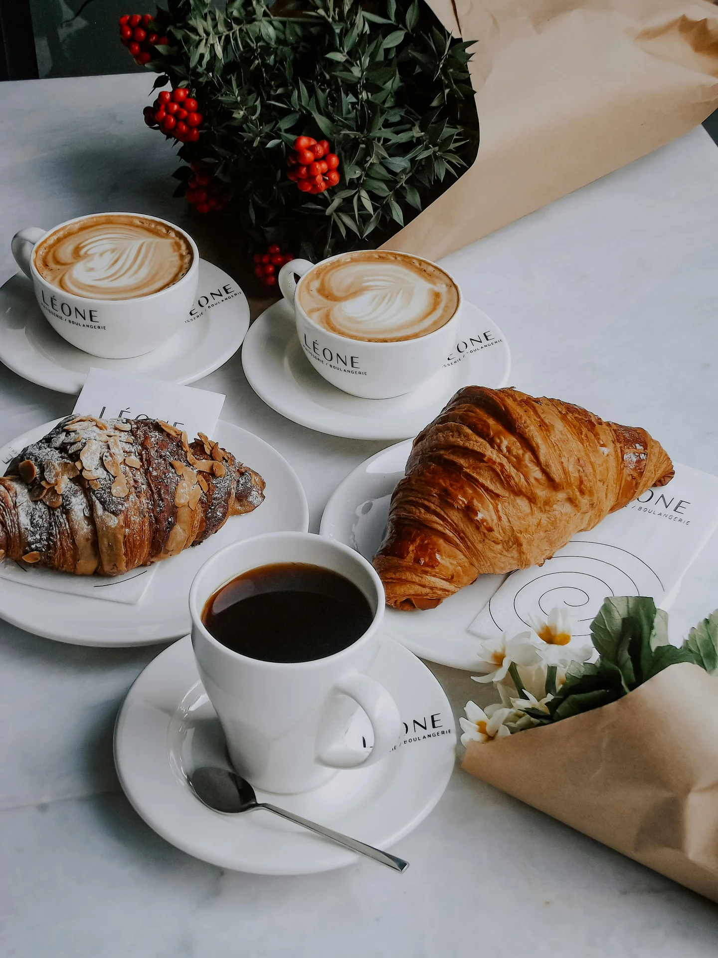 Different espresso drinks including cappuccino, americano, and croissants